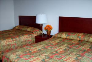 a hotel room with two beds and two lamps at Town and Mountain Hotel in Whitehorse