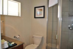 
a bathroom with a toilet a sink and a mirror at West Beach Inn, a Coast Hotel in Santa Barbara
