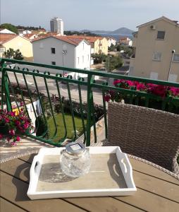 een glazen pot op een dienblad op een tafel op een balkon bij Apartman "Rosa" in Vodice