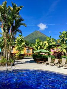 un complejo con piscina y montaña de fondo en Hotel Villas Vilma en Fortuna