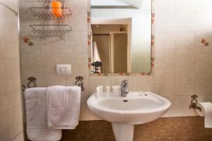 y baño con lavabo, espejo y toallas. en Casa Narciso en Polignano a Mare