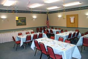una sala de banquetes con mesas y sillas con manteles blancos en Motel 6-Bloomsburg, PA, en Bloomsburg