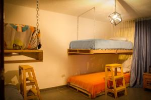 Zimmer mit 2 Etagenbetten und 2 Hockern in der Unterkunft Bababuy Hostel in Bogotá