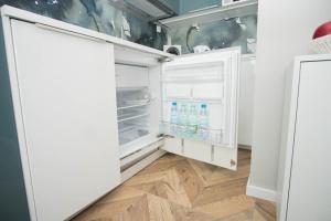 een open koelkast met flessen water erin bij Apartament Skwer 13 in Gdynia