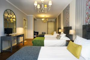 una camera d'albergo con due letti e una televisione di Charm Inn Sintra a Sintra