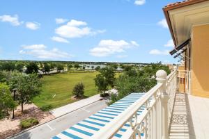 a balcony with blue and white stairs and a green field at Ave Maria Rentals Fl in Immokalee
