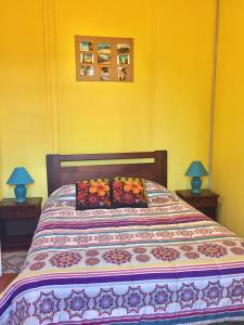 a bedroom with a bed with two lamps on two tables at Hotel Isla Bella Talca in Talca