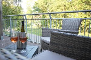 uma garrafa de vinho e dois copos numa mesa em Hotel Müritz-Park em Boek