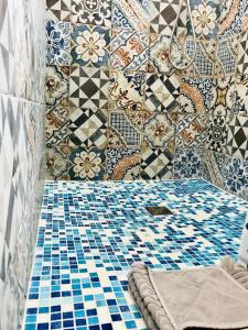 un bagno con piastrelle bianche e blu sul muro di Mare & Scogli a Polignano a Mare