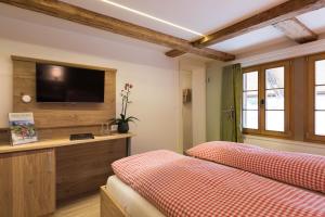 a hotel room with a bed, tv and a window at Hotel Restaurant Hirschen in Interlaken