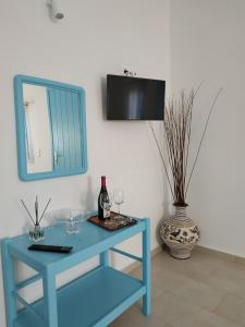 a blue table with wine glasses and a mirror at Fortina Mykonos house in Klouvas