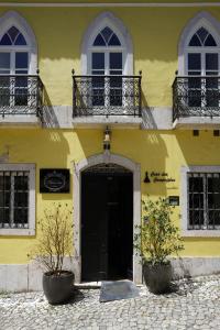 a yellow building with a black door and windows at Charm Inn Sintra in Sintra