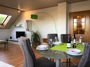 - une salle à manger avec une table, des chaises et des verres à vin dans l'établissement Steinbachblick, à Steinbach am Wald