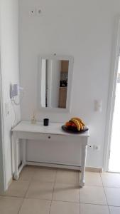 a white table with a mirror and bananas on it at Fortina Mykonos house in Klouvas