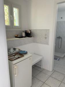 - une cuisine blanche avec un comptoir et un évier dans l'établissement Fortina Mykonos house, à Klouvas