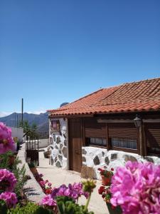 ein Gebäude mit lila Blumen davor in der Unterkunft Ilusiones in Tejeda