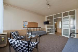 ein Zimmer mit einem Bett und Stühlen in einem Zimmer in der Unterkunft LEM Suburban Apartment in Budapest
