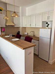 a kitchen with white cabinets and a white refrigerator at Luxury Studio Mamaia Nord in Mamaia Sat/Năvodari