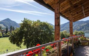 a balcony with red flowers and a view of mountains at Haus Panorama in Schliersee