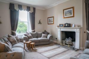 sala de estar con 2 sofás y chimenea en West Plean House en Stirling