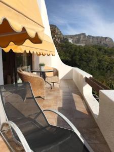 ein Balkon mit Stühlen und einem Tisch mit Aussicht in der Unterkunft Sunset Apartment in Kapstadt