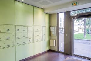 een kamer met kluisjes en een deur in een gebouw bij Appart'cosy Lyon Est in Décines-Charpieu