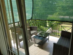 a balcony with chairs and a table and a view of the ocean at Sobe EMILIJA in Veliko Gradište