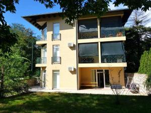 an apartment building with a balcony and a yard at Sobe EMILIJA in Veliko Gradište