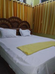 a bed with a yellow blanket on top of it at K.S.N. Varanasi Paying Guest House in Varanasi