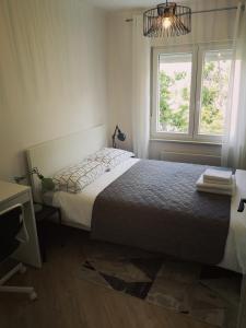 a bedroom with a bed and a window at Apartment Gervais Rijeka in Rijeka