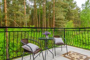 two chairs and a table on a balcony with trees at Willa Rowy in Rowy +20 photos
