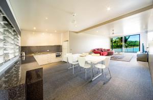a kitchen and living room with a white table and chairs at Baybliss Apartments 1 Bedroom WiFi in Shute Harbour
