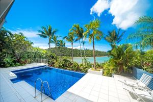 a villa with a swimming pool and a view of the ocean at Baybliss Escape #4 - Adults Only in Shute Harbour