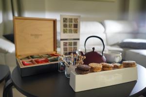 a table with a box of muffins and a tea kettle at Piccadilly Rooms Restaurant and Beach in Santa Maria al Bagno