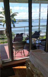 a room with a balcony with a view of the water at Suva Hideaway Villa in Suva