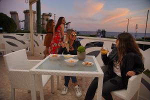 a group of women sitting around a table with food at Piccadilly Rooms Restaurant and Beach in Santa Maria al Bagno