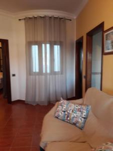 ein Wohnzimmer mit einem Sofa und einem Fenster in der Unterkunft Apartamento con terraza privada y barbacoa in La Laguna