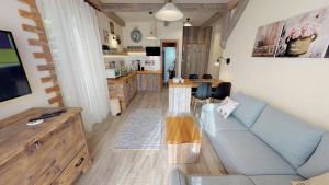 新斯莫柯維克的住宿－Apartmán Sofia s infrasaunou, PRIMO, Starý Smokovec，一间带蓝色沙发的客厅和一间厨房