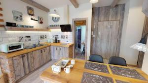 a kitchen with wooden cabinets and a table and chairs at Apartmán Sofia s infrasaunou, PRIMO, Starý Smokovec in Smokovce +20 photos