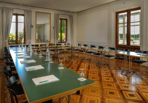 een grote kamer met een lange tafel en stoelen bij Château de Bossey in Bogis-Bossey