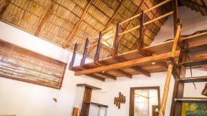 a room with a large wooden ceiling with wooden beams at Vibra Guesthouse Popoyo in Popoyo