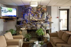 sala de estar con pared de piedra y TV en Valemount Vacation Inn, en Valemount