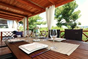 a wooden table with glasses of wine on it at MALUFI 193 in Jezera