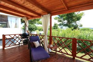 a porch with a chair and a table with a view at MALUFI 193 in Jezera