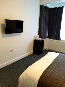 ロンドンにあるWanstead Hotelのベッドルーム1室(ベッド1台、壁掛け薄型テレビ付)