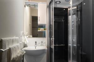 a white bathroom with a sink and a shower at Micro Boutique Living Wolfville in Wolfville +8 photos