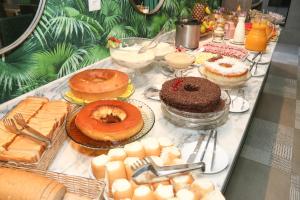a table with cakes and pastries and other desserts on it at Hotel da Praça in Bonito +42 photos