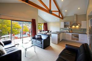 a living room with two couches and a kitchen at St James Apartments in Queenstown