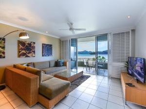 a living room with a couch and a tv at Hibiscus Apartments on Hamilton Island by HIHA in Hamilton Island