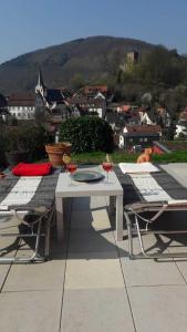 een tafel en stoelen op een patio met uitzicht op de stad bij Ferienwohnung Casa Rossa in Neckarsteinach